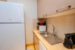 a small kitchen with a sink and a microwave at Istanbul Apartments in Istanbul +1 photo