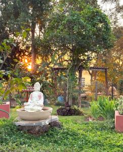 a statue sitting in a bowl in a garden at Sítio CEL com Suítes aconchegantes em Boituva in Boituva