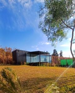 a glass building in a field with a tree at Cabana Ninho do Quero-Quero in Campo Largo +22 photos