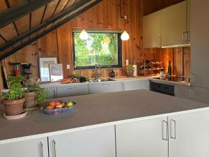 a kitchen with white cabinets and a bowl of fruit on a counter at Cozy Summer House With New Kitchen And Bathroom in Karrebæksminde +21 photos