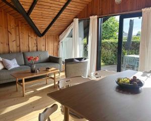 a living room with a table and chairs and a couch at Cozy Summer House With New Kitchen And Bathroom in Karrebæksminde