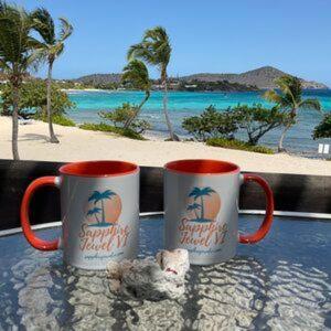 two coffee mugs sitting on a table in front of the beach at C206 - Sapphire Beach - Sapphire Jewel VI in East End