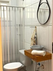 a bathroom with a toilet and a sink and a mirror at Sítio CEL com Suítes aconchegantes em Boituva in Boituva
