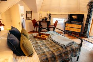 a bedroom with a bed and a table with chairs at 1 Romantic cabin for two with outdoor bath and Sauna! in Pont Sticill