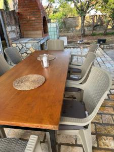 a wooden table with chairs and a cup on it at Villa Georgi in Ohrid