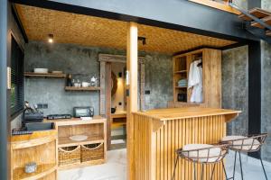 a kitchen with a counter and chairs in a room at Lorel Green Domain Ubud in Ubud