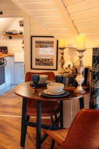 a table with plates and bowls on it in a kitchen at 1 Romantic cabin for two with outdoor bath and Sauna! in Pont Sticill