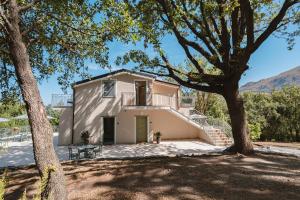 a house with a large tree in front of it at Dimora delle Acque - Altavista Residence in San Nicola Arcella