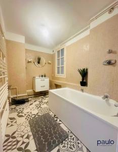 a large bathroom with a tub and a sink at Appartement Coeur de ville in Laon