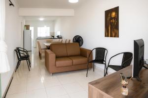 a living room with a couch and a table at Apartamento charmoso 3/4 in Ilhéus