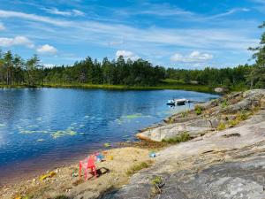 two red chairs sitting on the shore of a lake at Fredelig og landlig lavvoferie in Møkjåland
