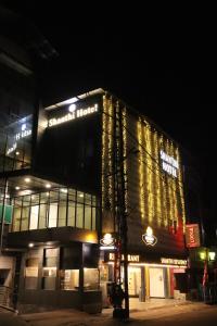 a building with a sign on it at night at Shanthi Tourist Home in Pathanāmthitta