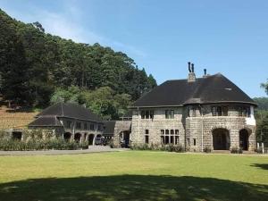 a large stone building with a black roof at Cool mount inn in Haputale