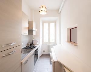 a white kitchen with a sink and a stove at Rainbow Residence in Cassino +6 photos