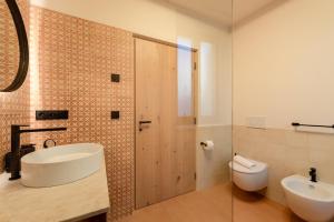 a bathroom with a sink and a toilet and a shower at Mendelglueck Apartments in Caldaro
