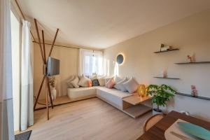 a living room with a white couch and a tv at Mendelglueck Apartments in Caldaro