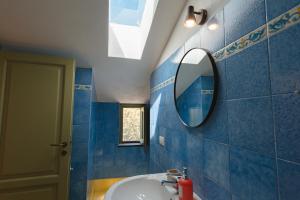 a blue tiled bathroom with a sink and a mirror at Dimora delle Acque - Altavista Residence in San Nicola Arcella +38 photos