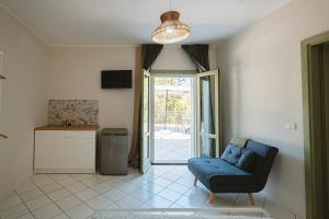 a living room with a blue chair and a sliding glass door at Dimora delle Acque - Altavista Residence in San Nicola Arcella
