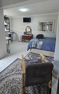 a bedroom with a bed and a couch and a chair at Upstairs R-4 Self Catering Unit in White River