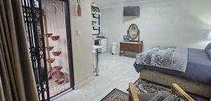 a bedroom with a bed and a bathroom with a mirror at Upstairs R-4 Self Catering Unit in White River