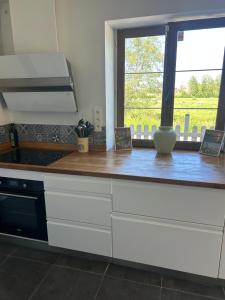 a kitchen with a wooden counter top with a window at Maison de campagne à 5 min de Nevers in Urzy