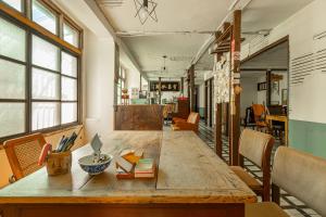 une salle à manger avec une grande table et des chaises en bois dans l'établissement Neat Hostel, à Tainan 141 autres photos
