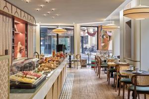 a restaurant with a buffet of food and tables at Hôtel Joséphine & SPA by HappyCulture in Paris
