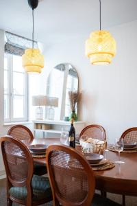 a dining room with a wooden table and chairs at La Maison Rouge de Givet in Givet