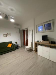 Una sala de estar con un sofá verde y un televisor. en Alloggio Turistico Mare Verde, en Gaeta
