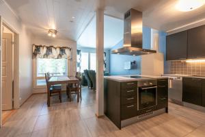 ルカにあるKotokuusi 2 - Monipuoliset ulkoilumahdollisuudet, sisältää siivouksenのテーブルとダイニングルームのあるキッチン