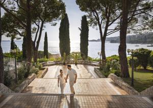 a man and a woman walking down a sidewalk at Remisens Hotel METROPOL in Portorož