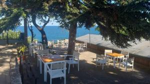 a group of tables and chairs next to the ocean at Bunaglows Panoramic Beach Village in Balchik +1 photo