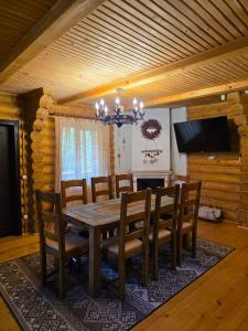 a dining room with a wooden table and chairs at Deep Forest 1 in Berehomet