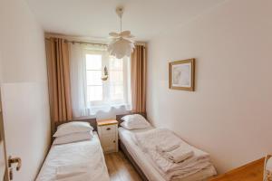 two beds in a room with a window at VacationClub - Leśny Dom 16A Apartament 14 in Karpacz