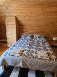 a bed in a room with a wooden wall at Deep Forest 1 in Berehomet +3 photos