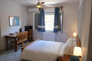 a bedroom with a bed and a desk and a window at Eviali Apartments in Limne