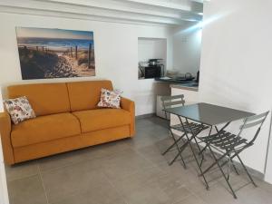 a living room with a couch and a table at Monolocale Zena in Carloforte