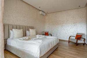 a bedroom with a large white bed and two chairs at Villa Lina in Marrakech +64 photos