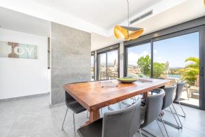 een eetkamer met een houten tafel en stoelen bij villasroyale Silvermoon in San Bartolomé