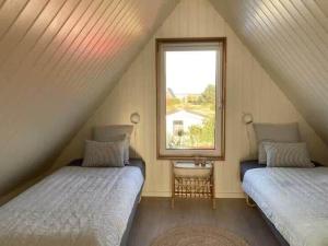a attic bedroom with two beds and a window at 1335-Vestervig-Spovevej-11 in Vestervig