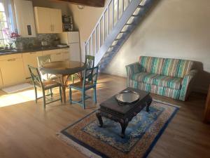 a living room with a table and a couch at Maison Bleue in Lavault-de-Frétoy +6 photos