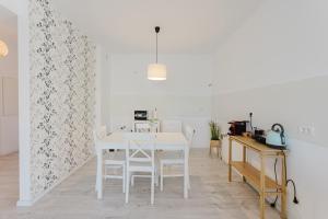 a white dining room with a white table and chairs at City Center Accommodation 111 in Reşiţa