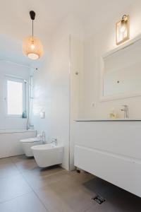 a white bathroom with a tub and a sink at City Center Accommodation 111 in Reşiţa