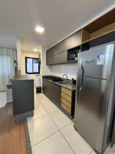 a kitchen with a stainless steel refrigerator and a counter at 2 Quartos c Ar, Wi-Fi e conforto perto de tudo in Maringá +24 photos