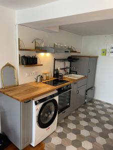 uma cozinha com um fogão e uma máquina de lavar roupa em Studio Cosy au charme Parisien - Butte aux cailles em Paris