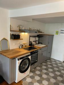 uma cozinha com pia e máquina de lavar em Studio Cosy au charme Parisien - Butte aux cailles em Paris