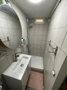 um banheiro com uma pia, um chuveiro e um espelho em Studio Cosy au charme Parisien - Butte aux cailles em Paris