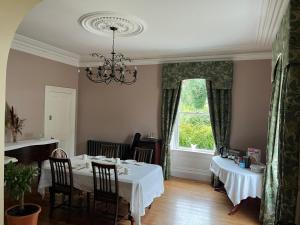 a dining room with a table and a chandelier at Dernacally House and Spa in Carrigans