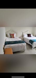 a bedroom with two beds with white sheets and pillows at Shanhai B&B in Jinning