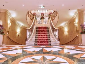 
a stairway leading to a large room with a clock on it at Grand Hotel Wien in Vienna
